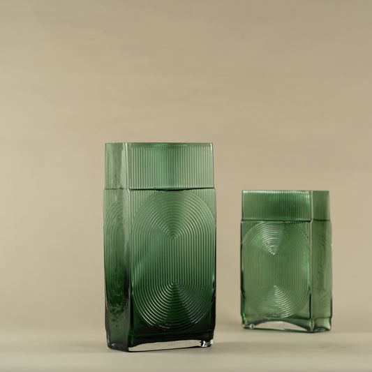 Green vase with baby's breath flowers on a beige background