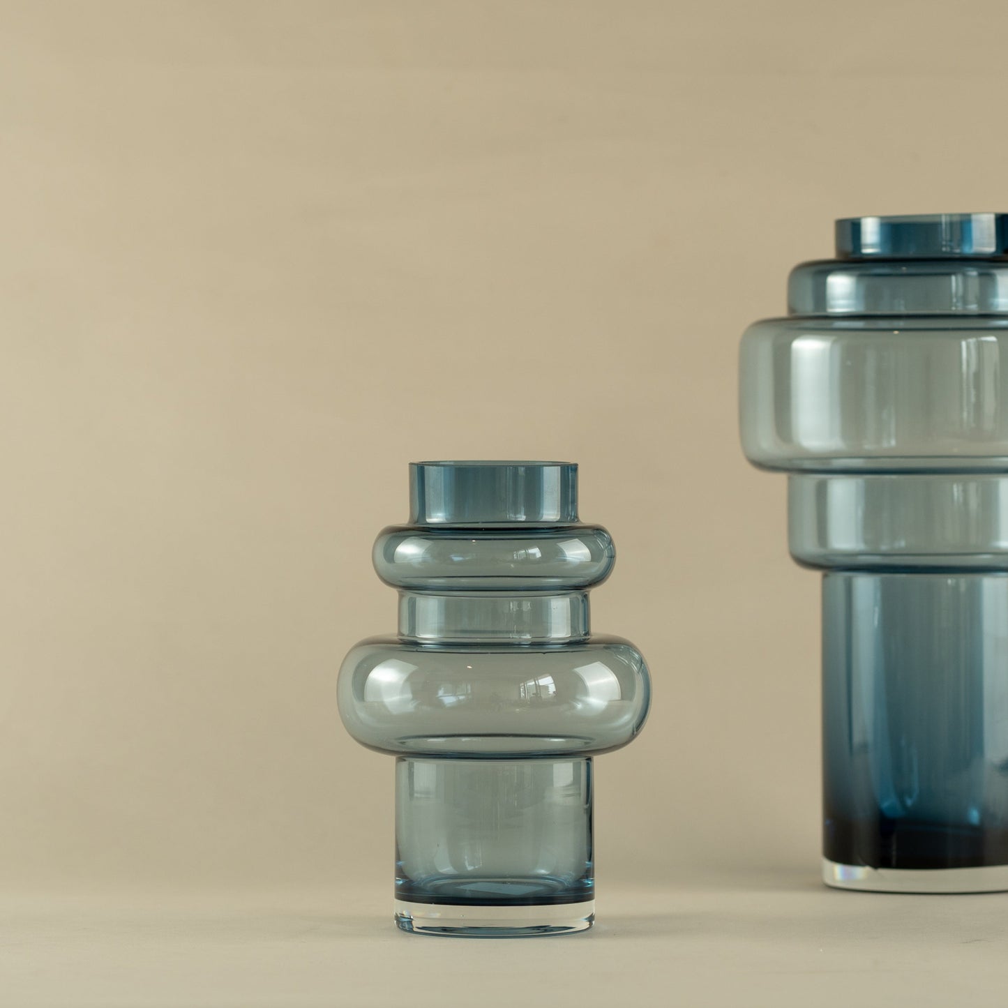 Two glass vases on a beige background
