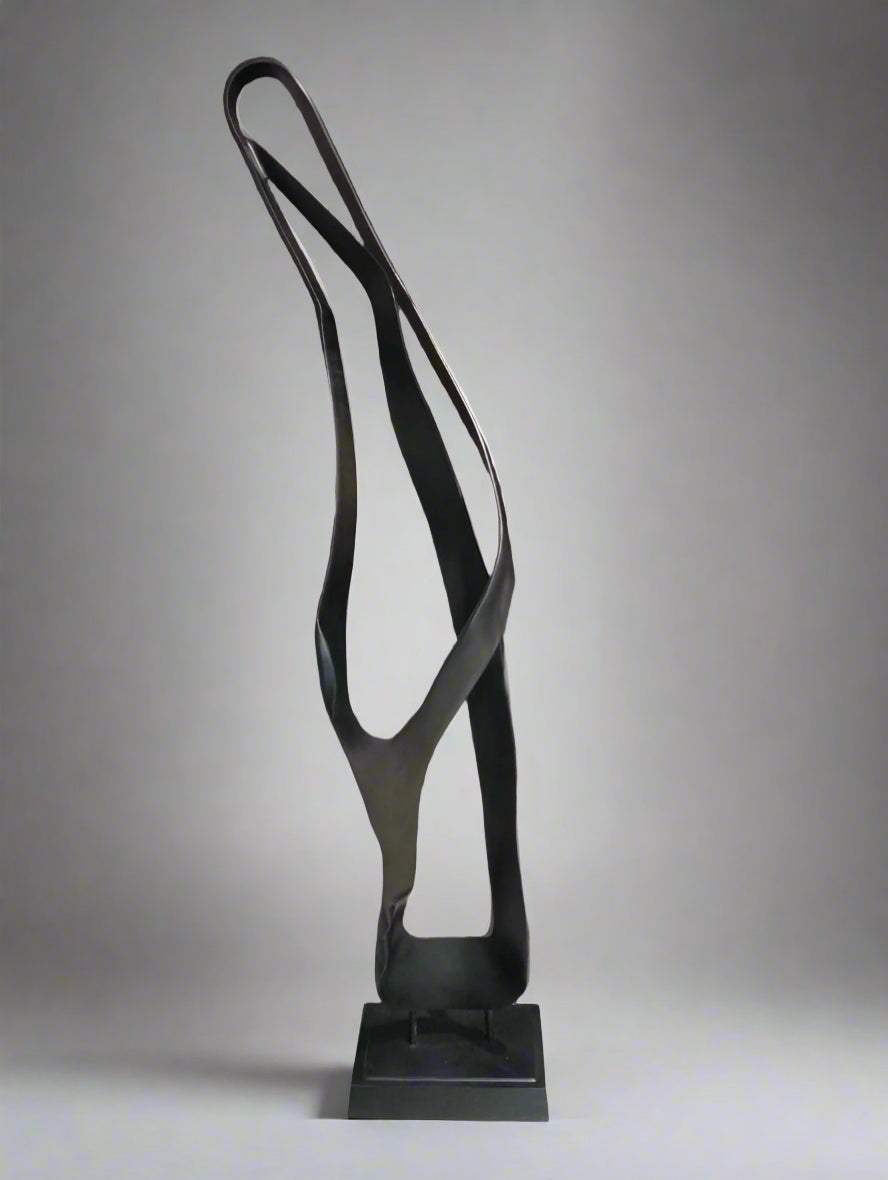 Black abstract sculpture on a stand against a neutral background