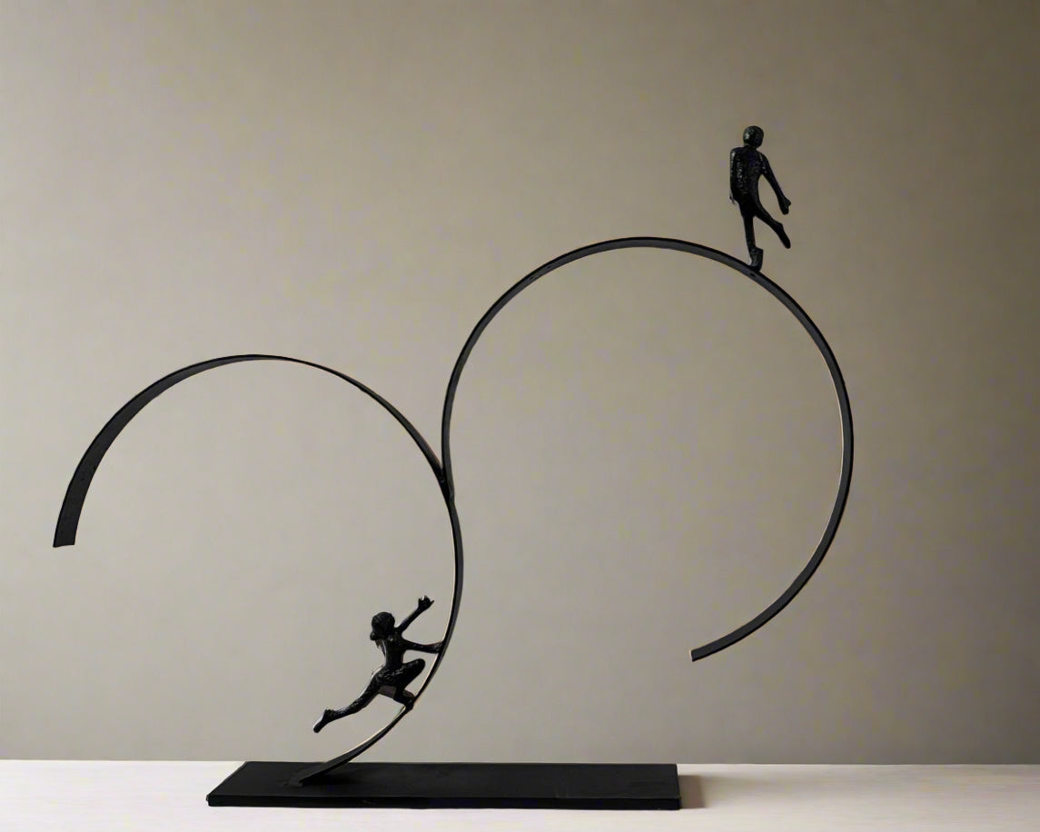 Sculpture of two people on interlocking rings against a white background