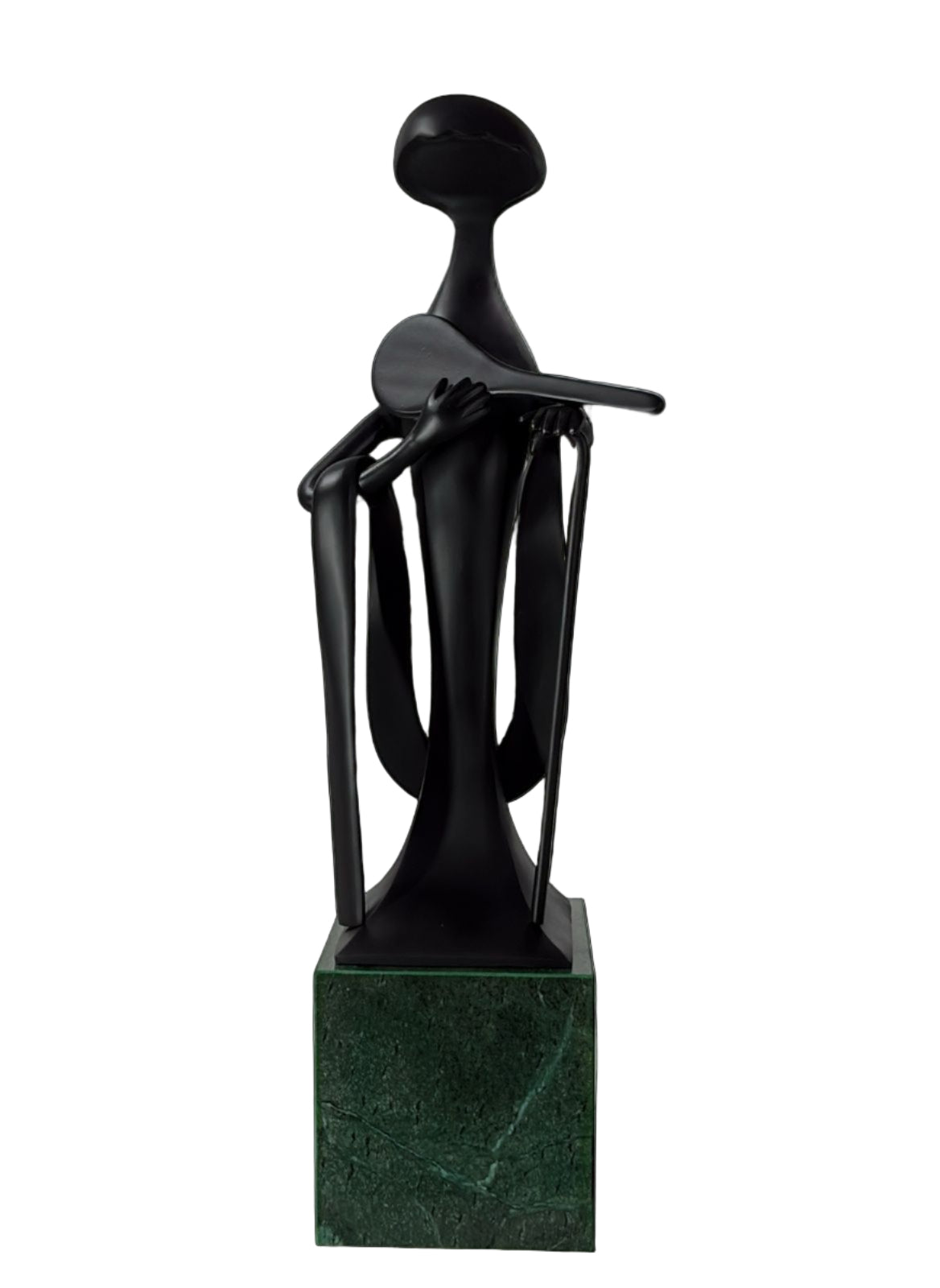 Black abstract sculpture on a green marble base against a light gray tiled wall.