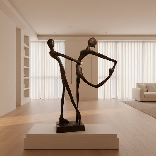 Bronze sculpture of two people holding hands on a white background