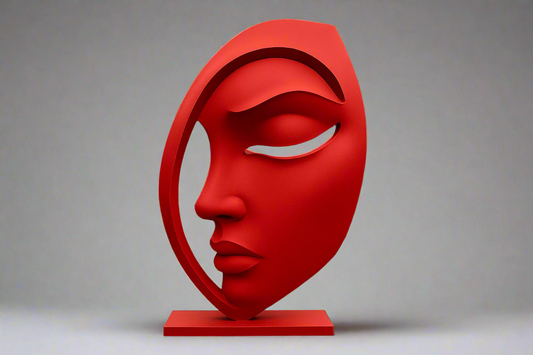 Red face sculpture in front of a black building