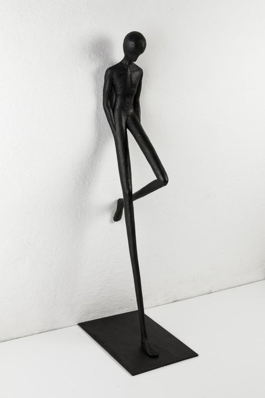 Modern interior with a sculpture of a dancing figure and hanging lights.