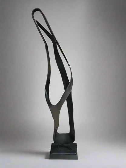 Black abstract sculpture on a stand against a neutral background