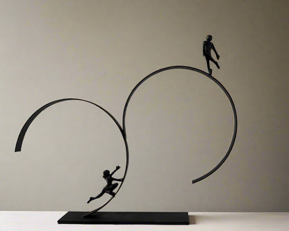 Sculpture of two people on interlocking rings against a white background