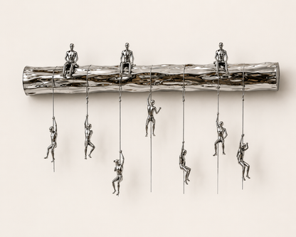 The Climbers contemporary luxury wall sculpture featuring colorful suspended figures climbing a polished metallic beam in a modern interior setting.